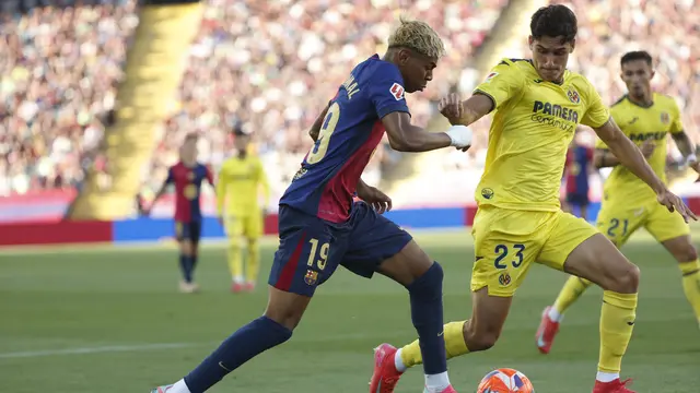 Pemain Barcelona, Lamine Yamal (kiri), berupaya melewati adangan bek Villarreal, Sergi Cardona, pada pekan 37 Liga Spanyol 2024/2025 di Lluis Companys Olympic Stadium, Senin (19/5/2025) dini hari WIB. (AP Photo/Joan Monfort)