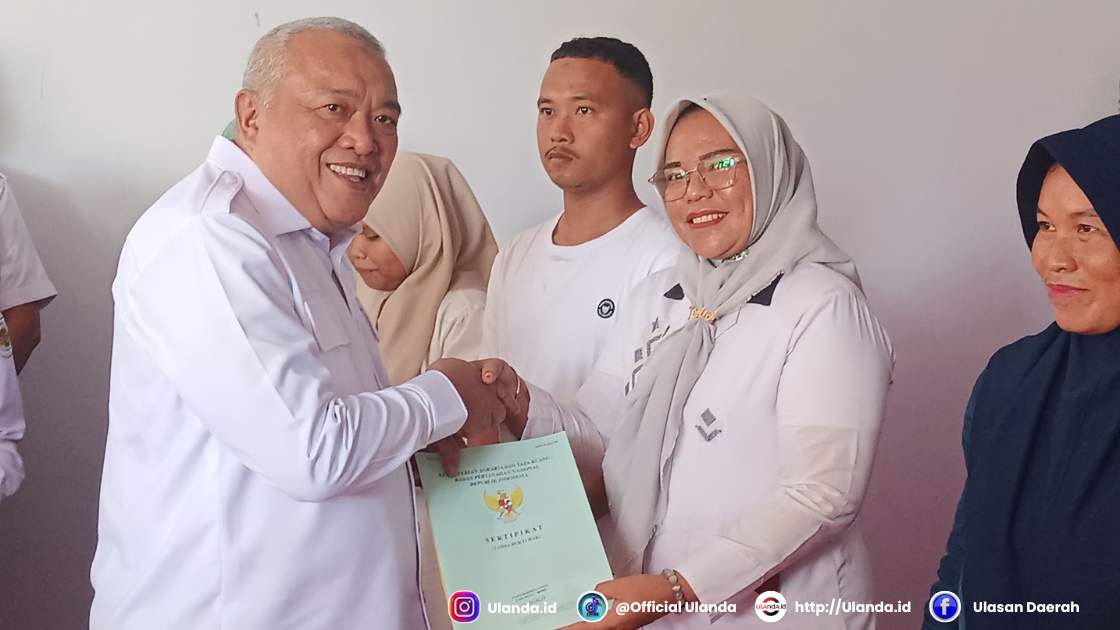 Wakil Bupati Gorontalo H. Tonny S. Junus menyerahkan sertifikat tanah program Pendaftaran Tanah Sistematis Lengkap (PTSL) kepada warga Desa Huidu