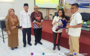 Penyerahan cinderamata dari dekan Fakultas Hukum Untad, Awaluddin kepada narasumber, Amanah Nurish.