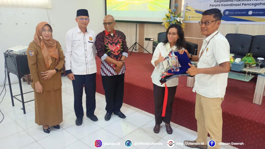 Penyerahan cinderamata dari dekan Fakultas Hukum Untad, Awaluddin kepada narasumber, Amanah Nurish.