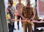 sekretaris dinas koperasi dan umkm bone bolango Rahman Bau saat melakukan pengguntingan pita persesmian kantor sekretariat KMP Oluhuta utara. senin, 23 juni 2025/fhoto.ulanda