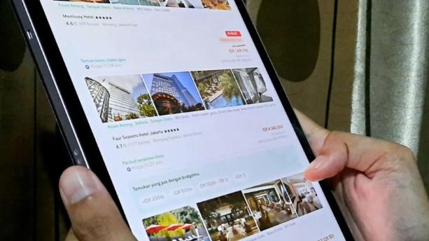 Konsumen membuka platform digital untuk memesan hotel.