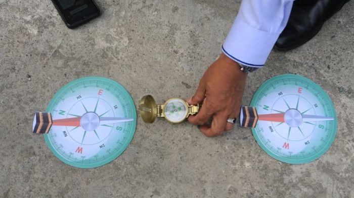 Kepala Kantor Kementerian Agama (Kemenag) Aceh Barat Abrar Zym (tengah) mengatur posisi kompas saat mengajarkan cara mengukur arah kiblat kepada siswa-siswi dengan menggunakan benda tegak lurus pada fenomena Rashdul Kiblat atau Istiwa A'zam, di Madrasah Aliyah Negeri (MAN) 1 Aceh Barat, Aceh (foto.Ist)