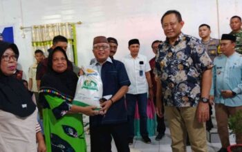 Bupati Gorontalo, Sofyan Puhi menyerahkan bantuan beras kepada masyarakat saat kegiatan penyaluran bantuan beras Cadangan Pangan Pemerintah (CPP) pada Jumat, 25 Juli 2025,(foto Humas Pemkab Gorontalo).