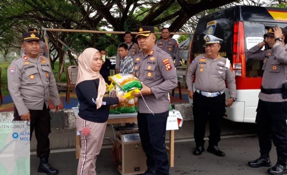 Kapolres Gorut AKBP Ahmad Eka Perkasa saat menyerahkan beras kepada salah seorang warga pada giat GPM yang digelar oleh polres Gorut, selasa, (12/8)-Foto:Ist/Ulanda.id