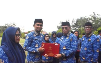 Sekda Iwan Mustapa saat menyerahkan penghargaan Satya Lencana kepada ASN saat memimpin Apel Korpri di Lapangan Alun-Alun Bone Bolango, Rabu (17/9/2025). (F. AKP/Diskominfo)/Ulanda.id