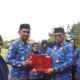 Sekda Iwan Mustapa saat menyerahkan penghargaan Satya Lencana kepada ASN saat memimpin Apel Korpri di Lapangan Alun-Alun Bone Bolango, Rabu (17/9/2025). (F. AKP/Diskominfo)/Ulanda.id