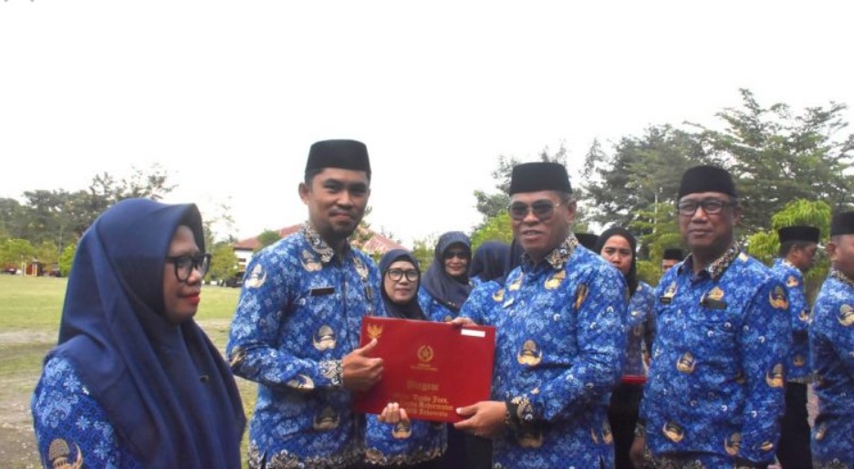 Sekda Iwan Mustapa saat menyerahkan penghargaan Satya Lencana kepada ASN saat memimpin Apel Korpri di Lapangan Alun-Alun Bone Bolango, Rabu (17/9/2025). (F. AKP/Diskominfo)/Ulanda.id